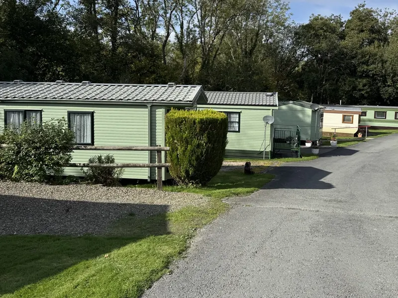 A row of holiday homes beside a quiet lane at Caerau Park